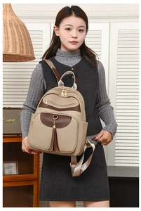 Detail of color-block backpack with pebbled leather texture and gold-tone zipper hardware