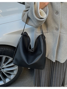 Dettaglio della trama in pelle martellata nera di una grande borsa hobo con fibbia