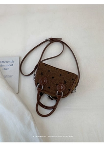 Close-up of retro polka dot tweed handbag with brown leather trim and silver hardware