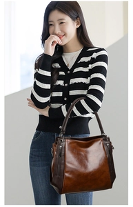 Detail of dark brown vintage faux leather tote bag with stylish vertical side zippers
