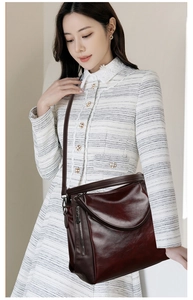 Detail of burgundy leather tote bag featuring glossy oil skin finish and silver zippers