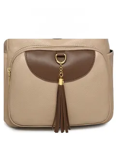 Detail of lychee pattern leather handbag with golden D-ring and brown leather tassels