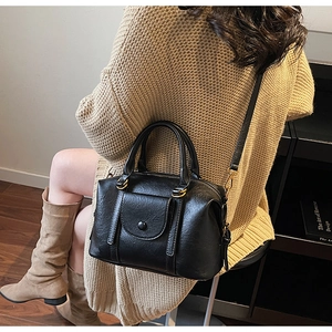 Gros plan d'un sac à main vintage noir avec texture plissée et boucles dorées