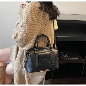 Détail d'un sac Boston vintage noir avec ferrures dorées et texture cuir grainé
