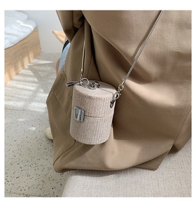 Macro shot of sparkling champagne sequined mini cylinder bag with silver chain strap