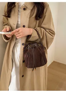 Detail of dark brown suede bucket bag with long fringe tassels and drawstring closure