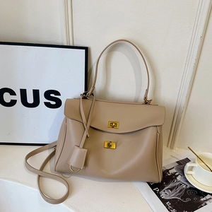 Minimalist apricot leather tote bag with gold twist locks and adjustable strap