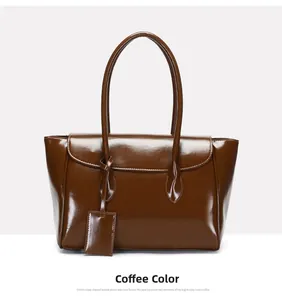 Detail view of coffee-colored glossy faux leather tote bag with thin dual handles