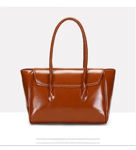 Detail of vintage dark brown faux leather tote bag with curved flap and adjustable strap
