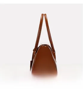 Side view of brown glossy leather tote bag showing stable triangular structure and handles