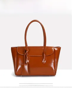 Detailed view of the brown glossy leather finish and flip cover on this large tote bag
