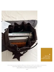 Top view of spacious interior of brown bucket bag holding books, umbrella and tablet