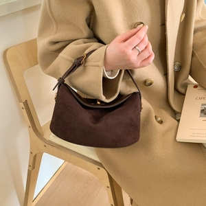 Retro brown suede dumpling bag with gold hardware worn with a beige wool coat