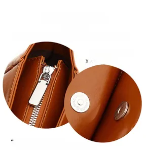 Close-up of premium silver hardware, zipper, and magnetic buckle on brown leather tote
