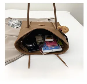 Detail view of large brown tote bag showing spacious interior with iPad and daily essentials