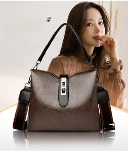 Detail of dark brown leather bucket bag showing silver metal twist lock and wide strap