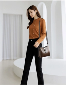 Close-up of a brown lychee pattern leather bucket bag with a stylish gold metal clasp