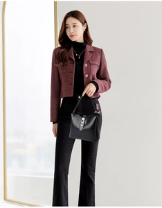 Detail of a black leather bucket bag featuring a minimalist silver buckle and wide strap