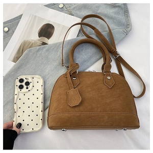 Vue détaillée du sac bandoulière marron semi-circulaire en cuir avec clous de protection