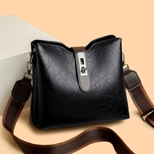 Large black leather bucket bag with brown wide strap and silver metal clasp
