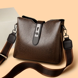 Dark brown leather bucket bag with wide striped strap and vintage metal lock closure