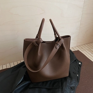 Minimalist dark brown litchi grain bucket bag with dual handles and crossbody strap