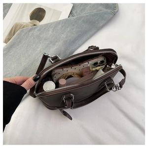 Vue intérieure du sac coquille en cuir marron foncé montrant une grande capacité de rangement