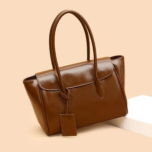 Glossy dark brown large capacity tote bag with long handles in a studio setting