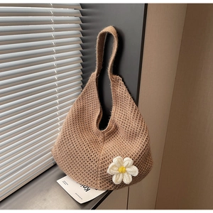 Detail of hand-knitted tote bag with floral 3D daisy accent and rustic crochet texture