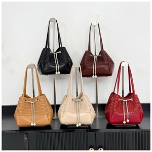 Detail of five crocodile texture bucket bags featuring pearl drawstring and chain straps