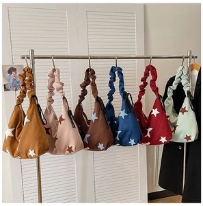 Detail of multi-color corduroy tote bags with star patterns and pleated shoulder straps