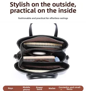 Internal view of the black leather tote bag showing multi-compartment storage and zipper