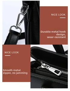 Detail of silver hardware hooks and smooth metal zippers on a black leather tote bag