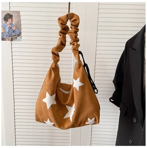 Detail of caramel suede bag featuring white star patch and stylish ruched shoulder strap