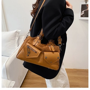 Close-up of caramel brown motorcycle bag with leather and suede textures on model