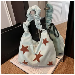 Close-up of mint green hobo bag with cloud-style pleated handle and star patch detail