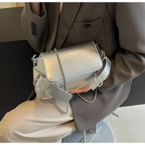 Close-up of stylish silver chain bag featuring a decorative strap buckle and metallic finish