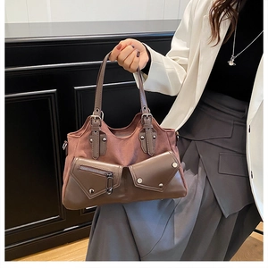Detail of vintage patchwork leather handbag featuring rivet pockets and suede textures