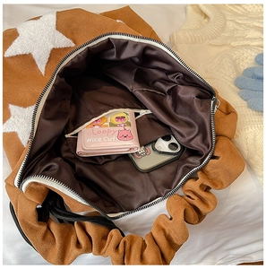 Interior detail of brown suede tote bag showing large capacity and zipper pocket