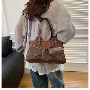 Detailed view of vintage mocha brown leather bag with silver rivets and double pockets
