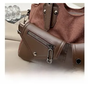 Detail of brown suede and leather stitching with unique pin zipper pull and rivets