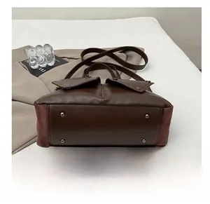 Close-up of leather bag bottom with four metal studs for durability and protection