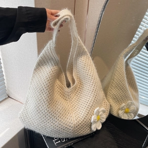 Minimalist beige knit hobo bag with daisy flower detail and soft woven texture