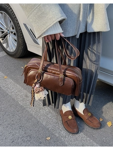 Detail of dark brown retro PU leather underarm bag with cute plush bear keychain