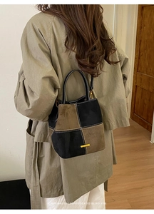 Retro contrast color patchwork denim bucket bag shown on model with khaki trench coat