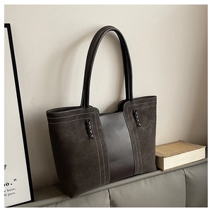 Bolso tote vintage minimalista con costuras en contraste y texturas en vista detallada