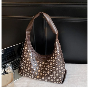 Detail shot of vintage dark brown crescent bag with silver rivet studs and thick handle