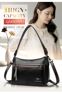 Detail of black lychee grain crossbody bag with silver kangaroo logo and contrast brown edging