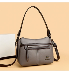 Detail of dark grey litchi grain leather handbag with contrast brown edges and logo