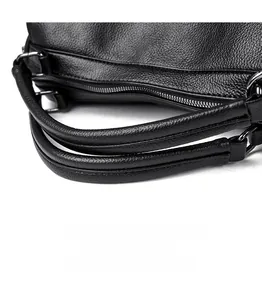 Détail de la texture cuir grainé et des finitions métalliques du sac à bandoulière noir
